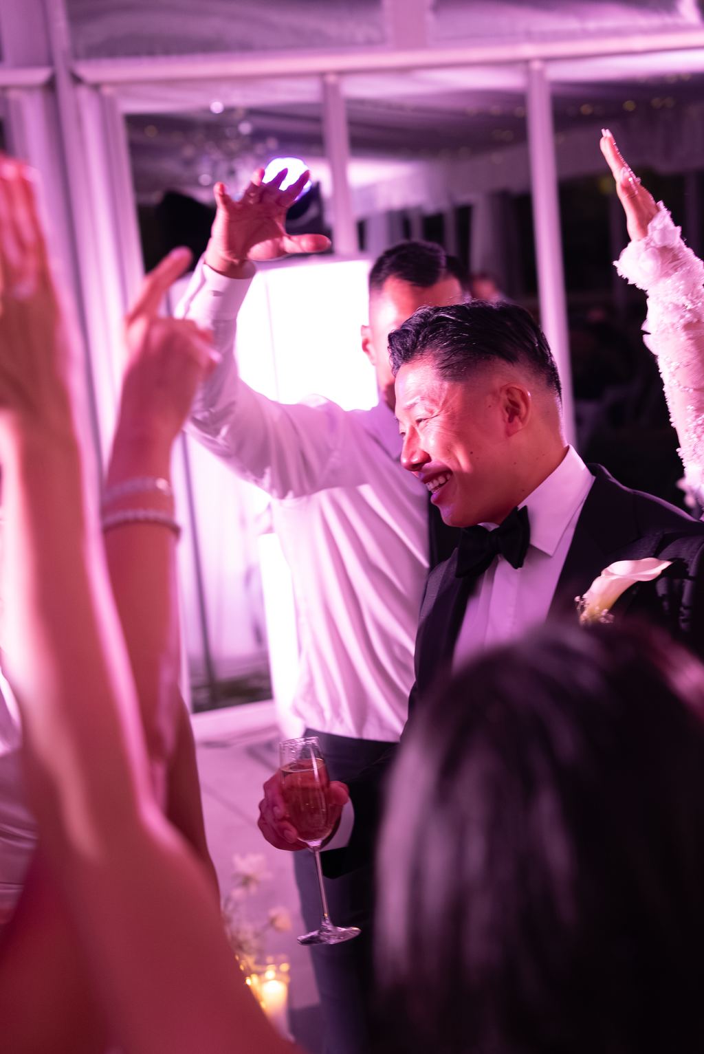Guests with hands raised, dancing and celebrating on the dance floor