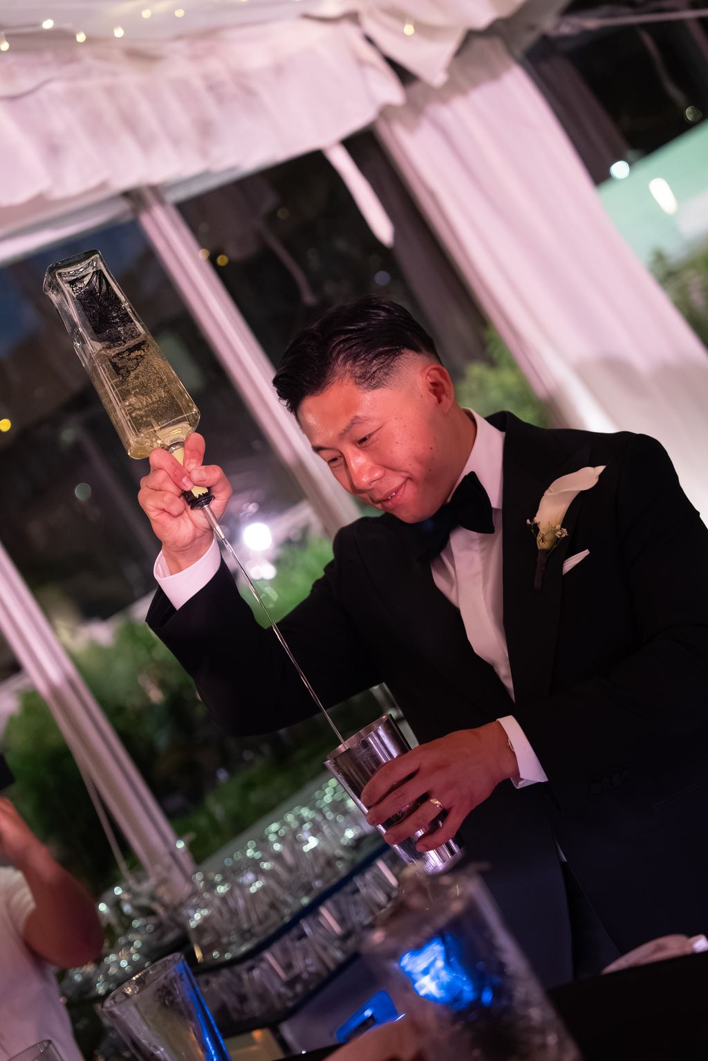 Groom sabering a champagne bottle at the reception